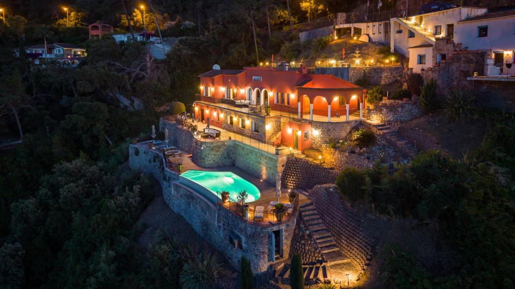 an aerial view of a house with a swimming pool at night at La Coraillère Waterfront Villa with Private Pool and Sea Access in Théoule-sur-Mer
