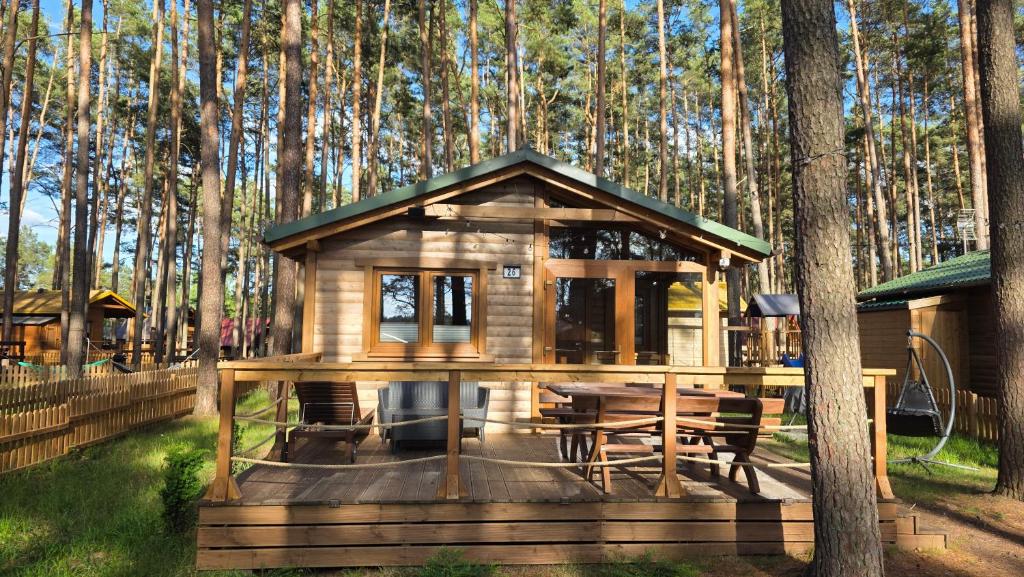 a cabin in the woods with a table and chairs at LAZY DAYS domek nr 26 w Borsku in Borsk