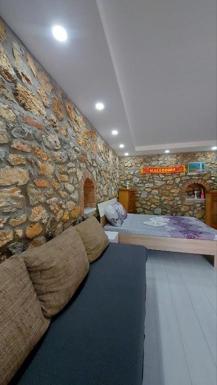 a room with a stone wall with a bed in it at Guest House Nadol SUP and Bikes included in Ohrid
