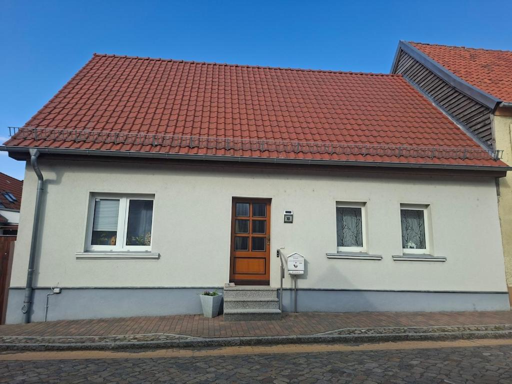 a white house with a red roof at Ferienhaus Petig in Pritzerbe