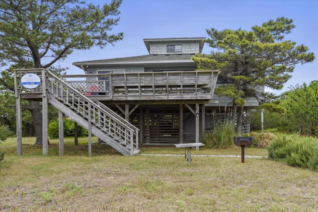 a large house with a deck and a staircase at Hurricane Charlie's in Duck