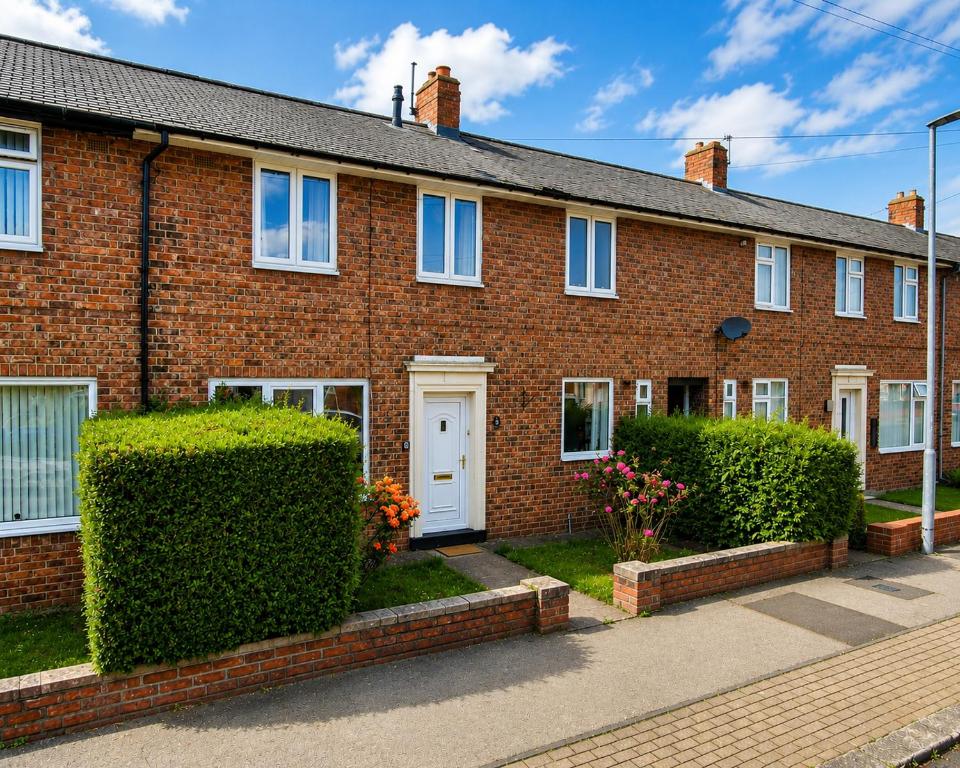 a red brick house with bushes in front of it at Modern 3BR Close to Durham Centre in Gilesgate