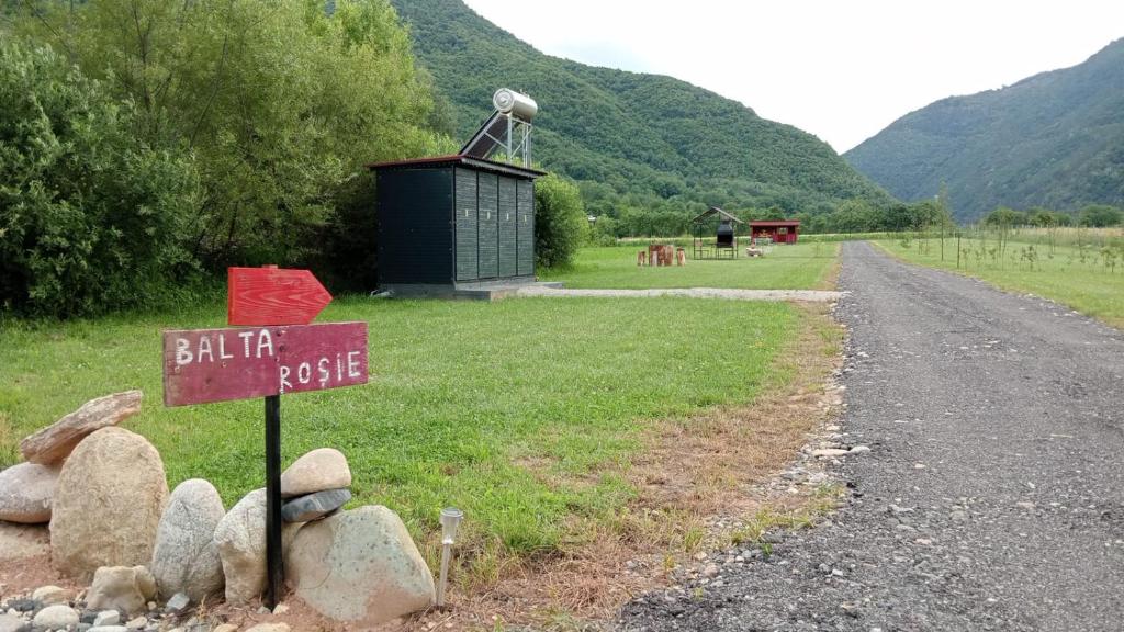 a sign on the side of a dirt road at Balta Roșie in Râu de Mori