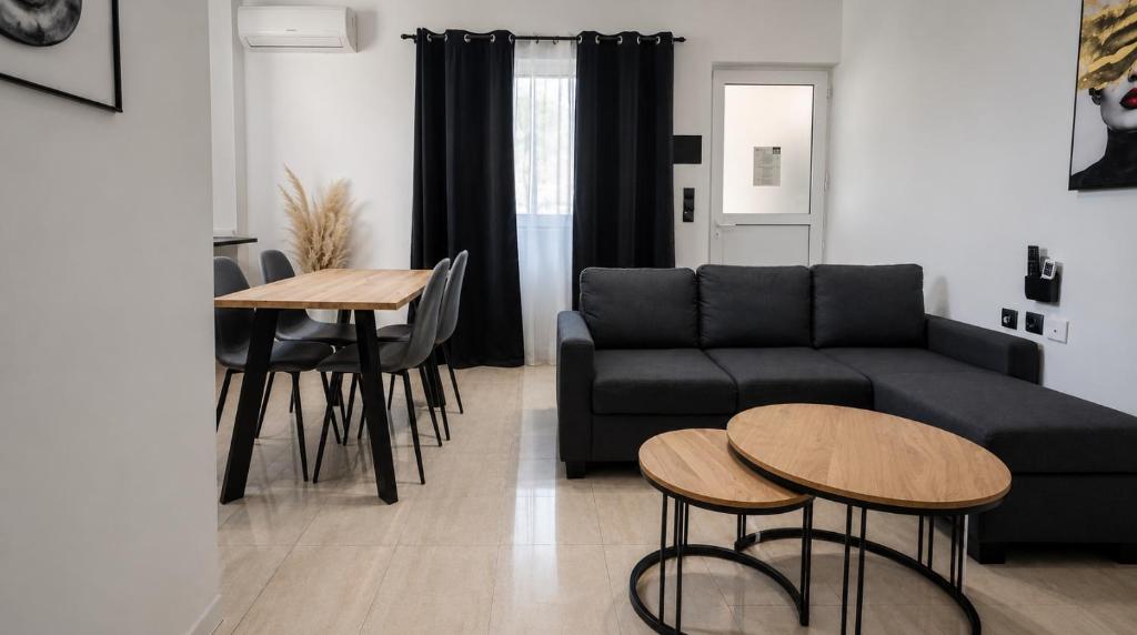 a living room with a couch and a table and chairs at Aleka Apartment in Kos