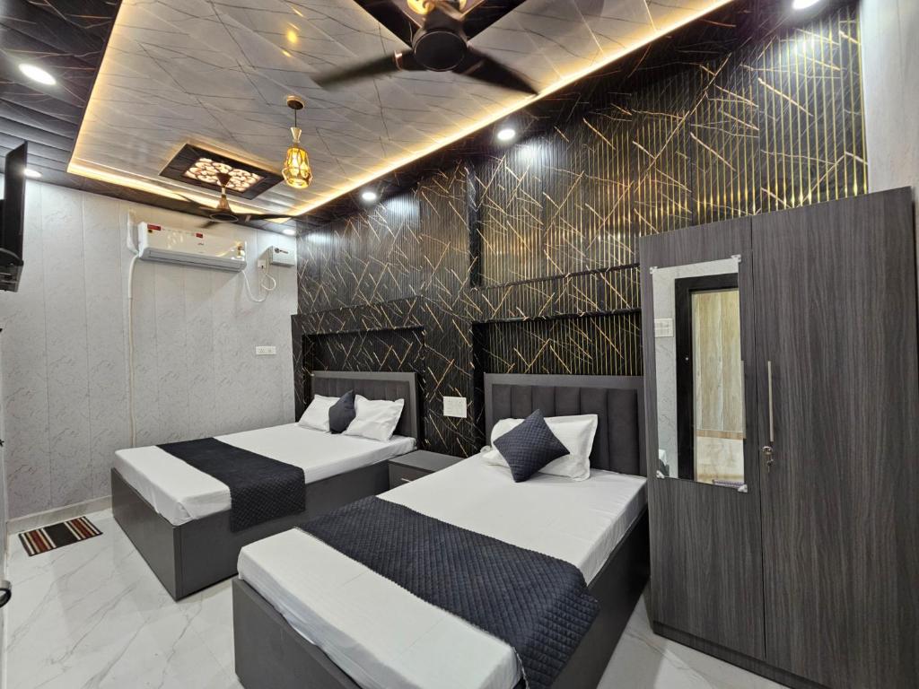 a room with two beds and a ceiling fan at Royal Rani Residency in Ayodhya
