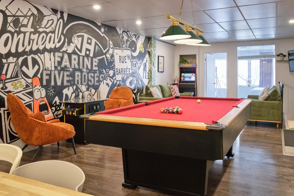 a room with a pool table in front of a wall at MtlVacationRentals - The Entertainer in Montreal