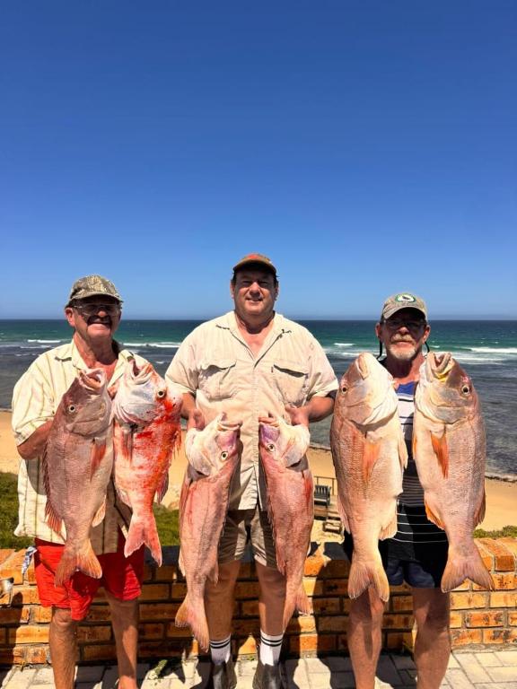 a group of four men holding up their fish at Vinknes in Boknes