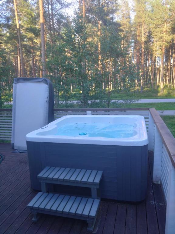 a hot tub sitting on a deck with a bench at Kurjenpesä in Kalajoki