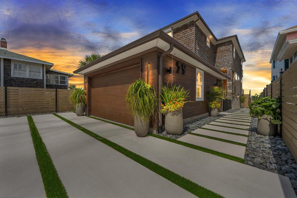 a house with potted plants in front of it at Seaview Serenity - Team Joseph Ellen in Jacksonville Beach