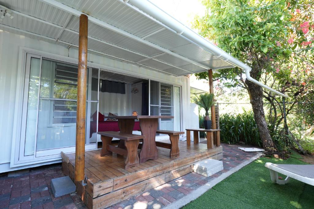 a wooden deck with a picnic table on a house at Libertas in Pointe d'Esny