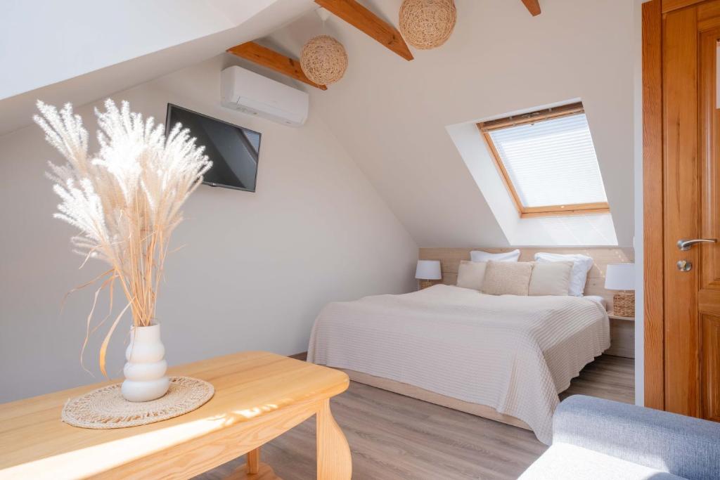 a bedroom with a bed and a vase on a table at Nida Inn Self Check-in in Nida