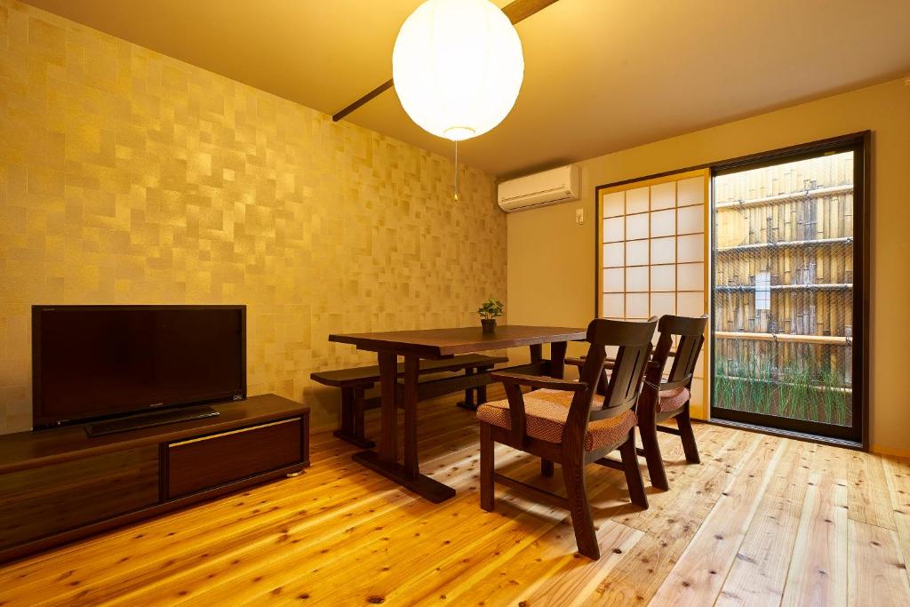 a dining room with a table and a television at Kyoyado Hakuto in Kyoto
