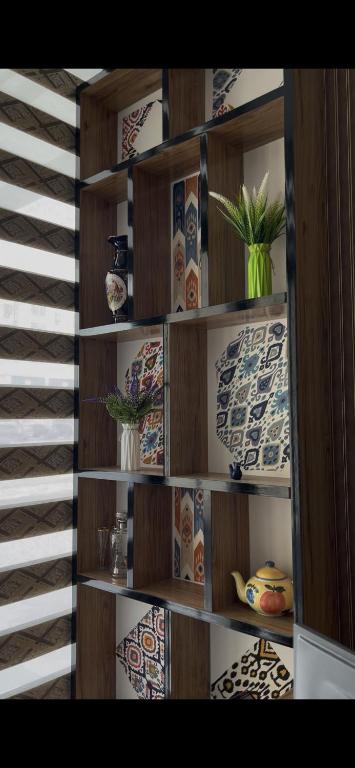 a book shelf with plates and vases on it at Hotel Santal in Bukhara