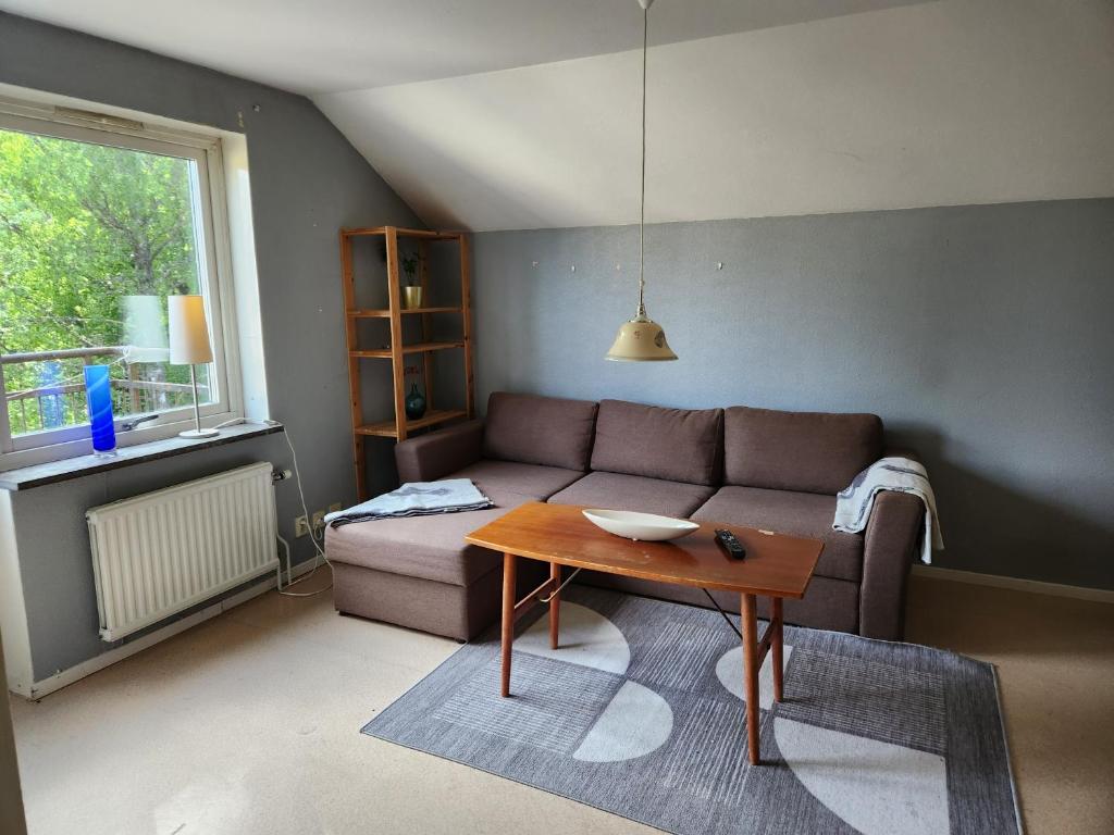 a living room with a couch and a table at Apartment with some lake view in Sävsjöström