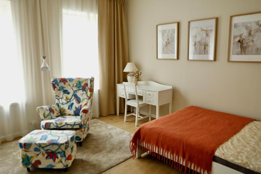 a bedroom with a bed and a chair and a desk at Center of city apartments, bus station 1min, airport 5 min in Tallinn