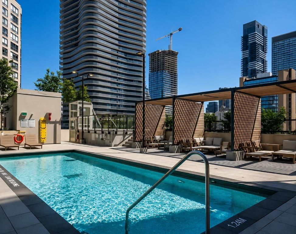 a swimming pool with chairs and a building at Regis Suites - Downtown Toronto in Toronto