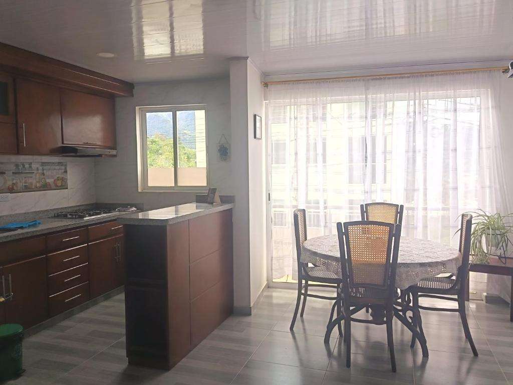 a kitchen with a table and chairs and a table and a window at Casa Bercel in Choachí