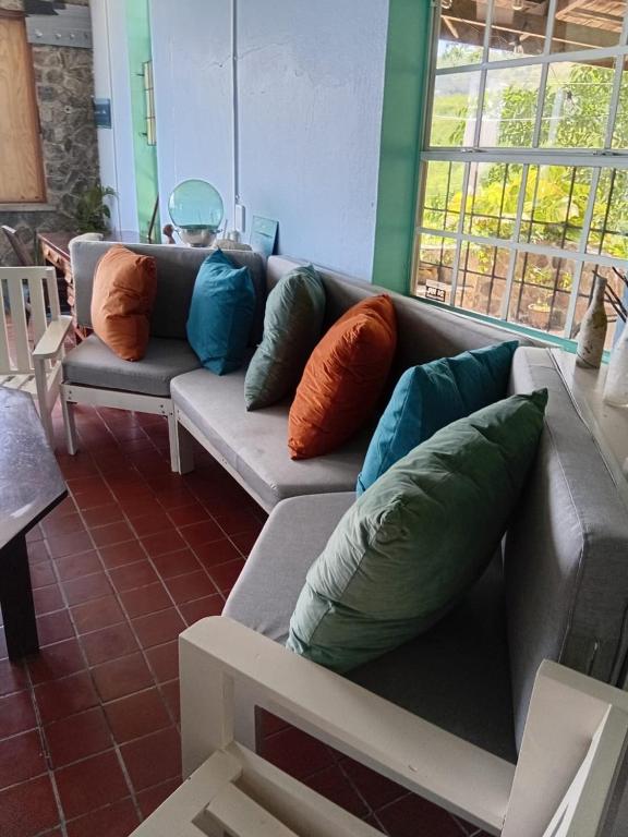 a living room with a couch with pillows on it at Trinity Point Hillside Villa, beach & sunset views in Bequia