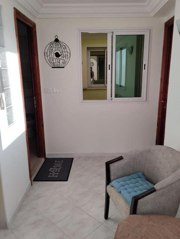 a living room with a chair and a mirror at Dar Fouzia in Hammamet Sud