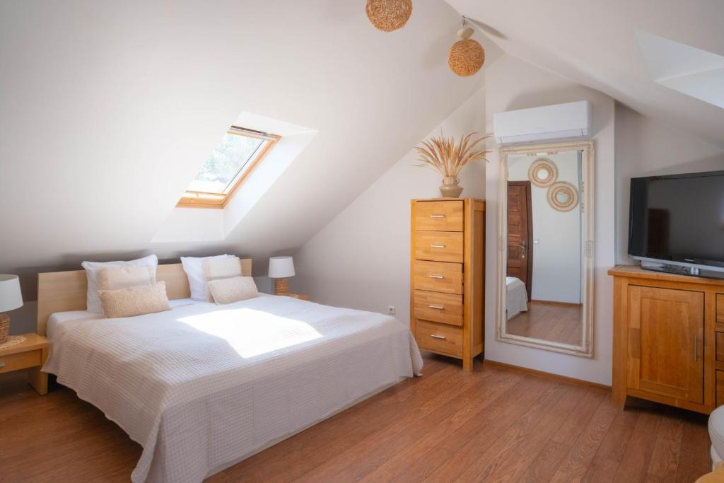 a bedroom with a white bed and a television at Laguna Self Check-in in Nida