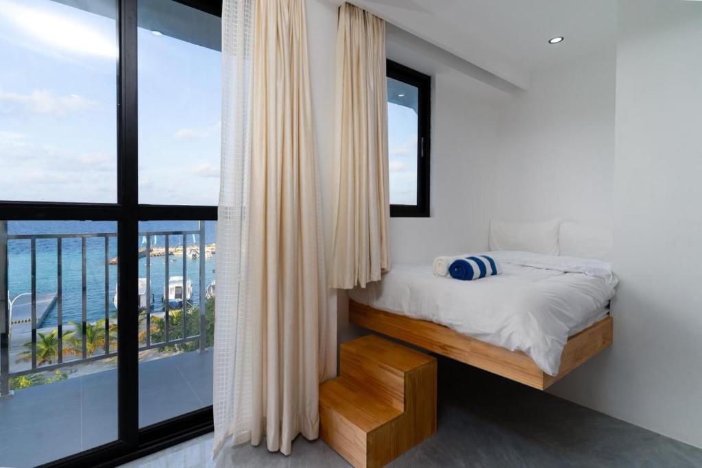 a bedroom with a bed and a large window at Seaside Oceanview in Ukulhas