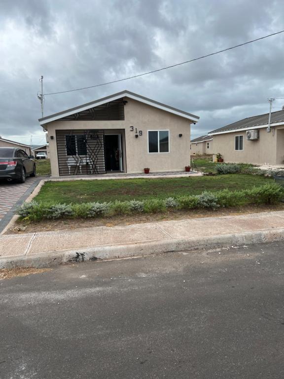 a house with a car parked in front of it at Comfort Rest - Whim in Old Harbour