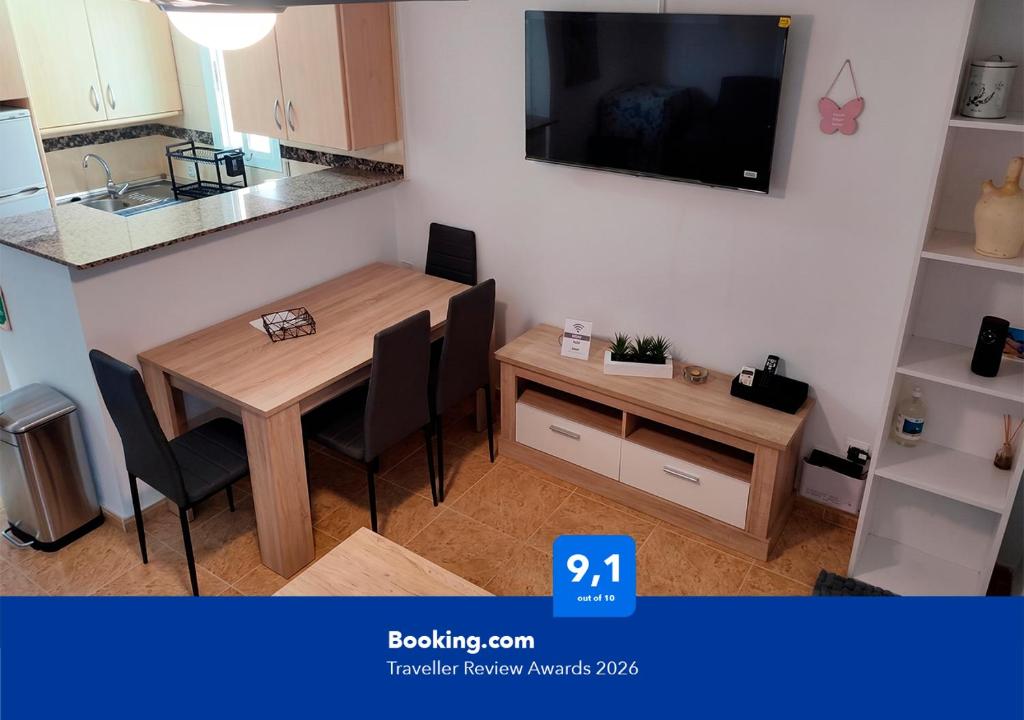 a small kitchen with a wooden table and chairs at Apartalux Sublime Plus in Las Negras