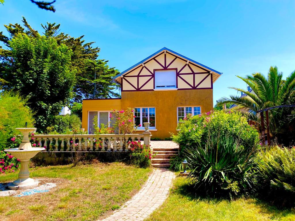 a yellow house with a fence in front of it at Mathéro in Saint-Pair-sur-Mer