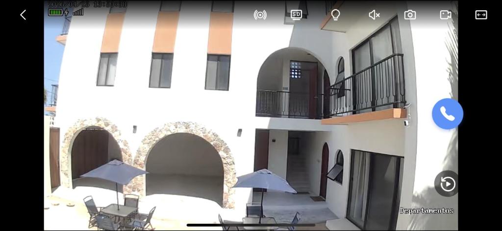 a building with chairs and umbrellas in front of it at Casa Laura Azul in El Cuyo
