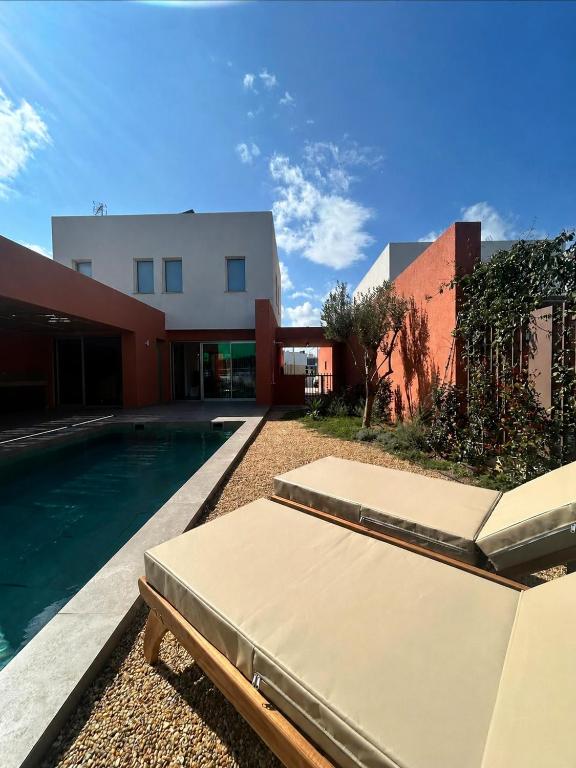 a house with a swimming pool next to a building at Terra Rossa Residences in Paralimni