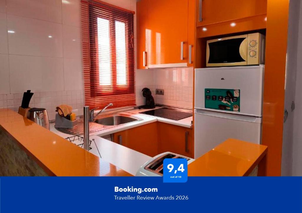 a kitchen with orange walls and a white refrigerator at Apartalux Pax Palace in Las Negras