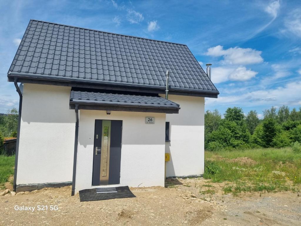 a small white building with a black roof at Domek na Sowiej in Kłodzko