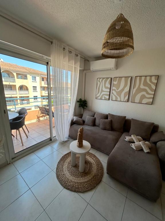 a living room with a couch and a table at Appartement frejus in Fréjus