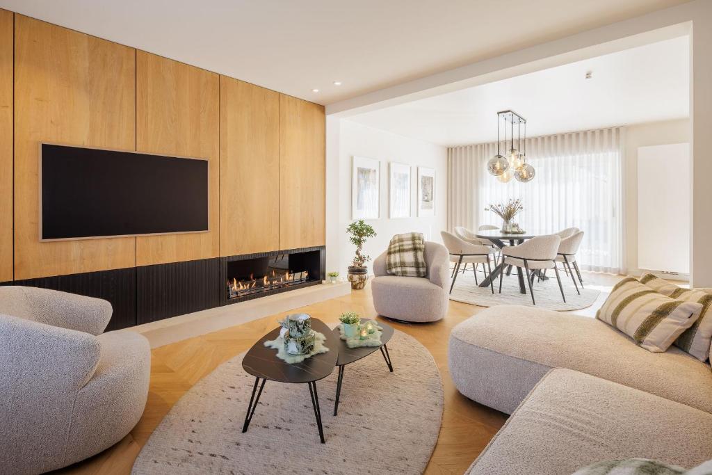 a living room with a fireplace and a tv at The Edewallenaar in Kortemark