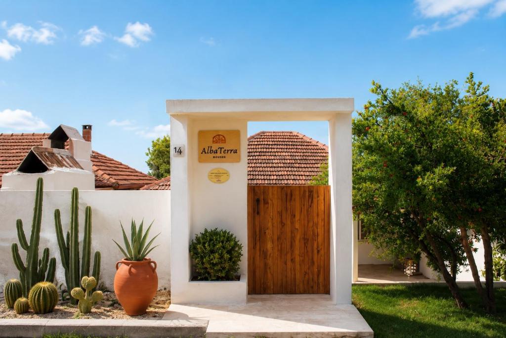 a wooden door in a yard with cactus at Alba Terra Houses in Pamukkale