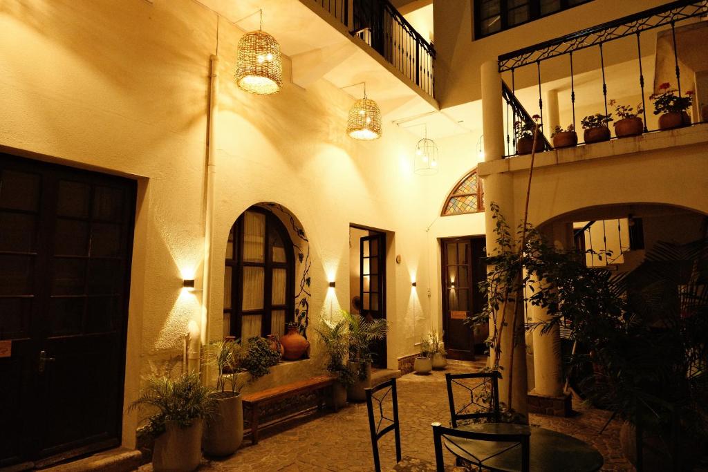 a hallway of a building with tables and chairs at Hotel Pata y Perro in Tarija
