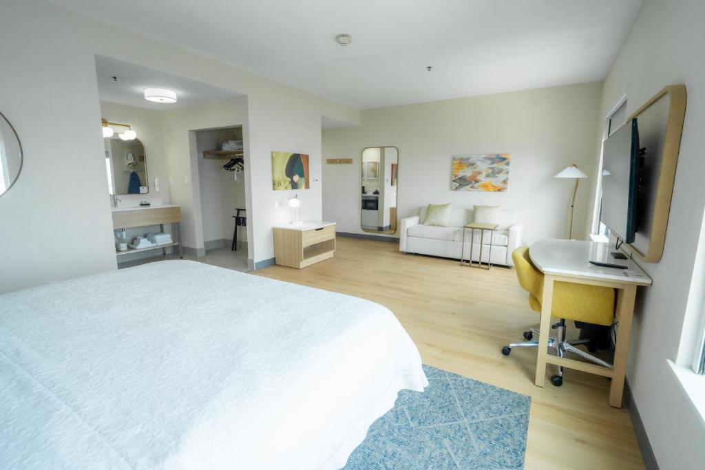 a bedroom with a bed and a desk and a television at Hampton Inn & Suites Mission in Mission