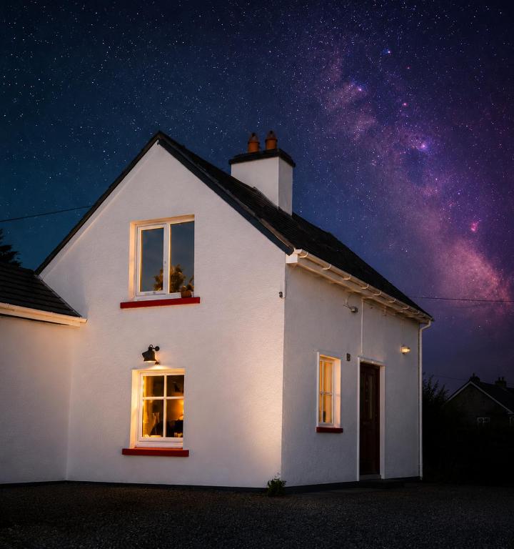 a white house at night with the milky way at Peaceful Cottage in Cork