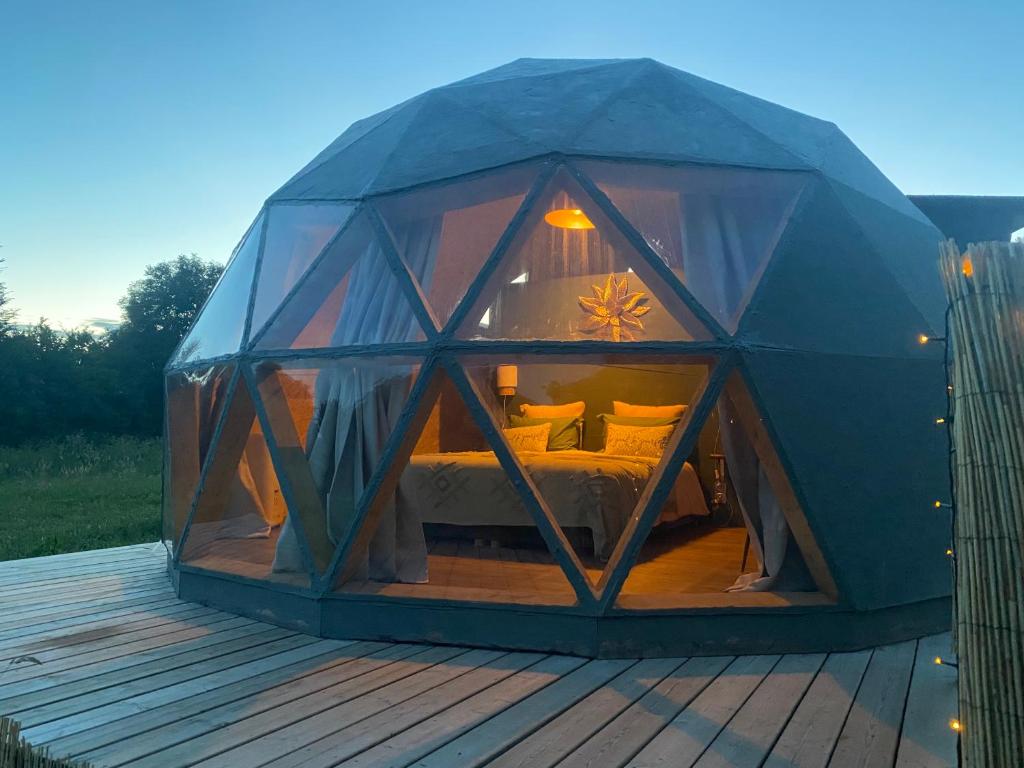 a bedroom inside of a iguana tent on a deck at le dôme avec bain nordique in Amfroipret