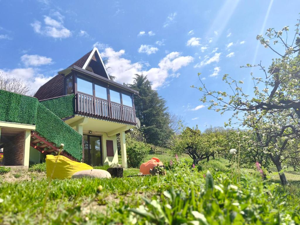 a house with a green roof on a grass field at Iza sedam gora in Rakovac