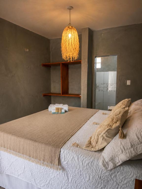 a bedroom with a large bed with a chandelier at Kayma Beach in Guriú