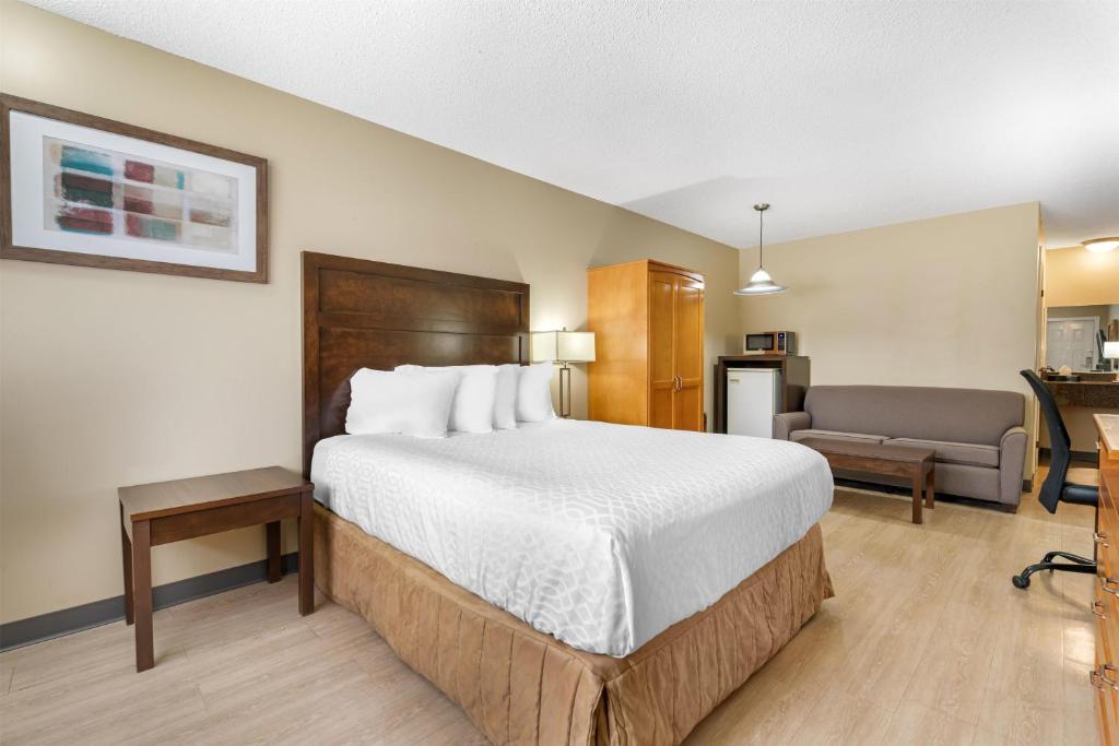 a hotel room with a bed and a couch at SureStay Plus Hotel by Best Western Salmon Arm in Salmon Arm