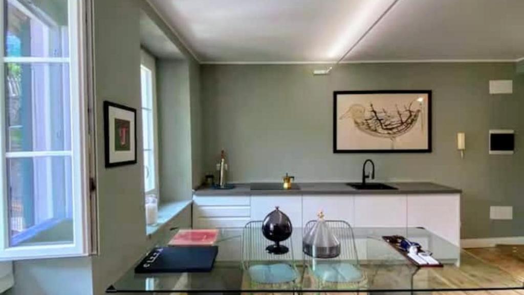 a kitchen with a glass table and a sink at Loft Library by Lago Maggiore Rentals in Oggebio