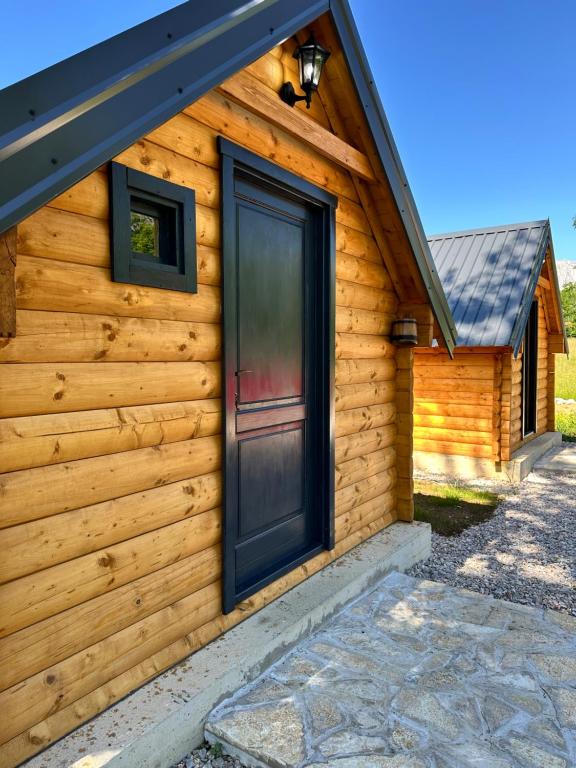 a log cabin with a black door on it at Log Cabin in Blatina