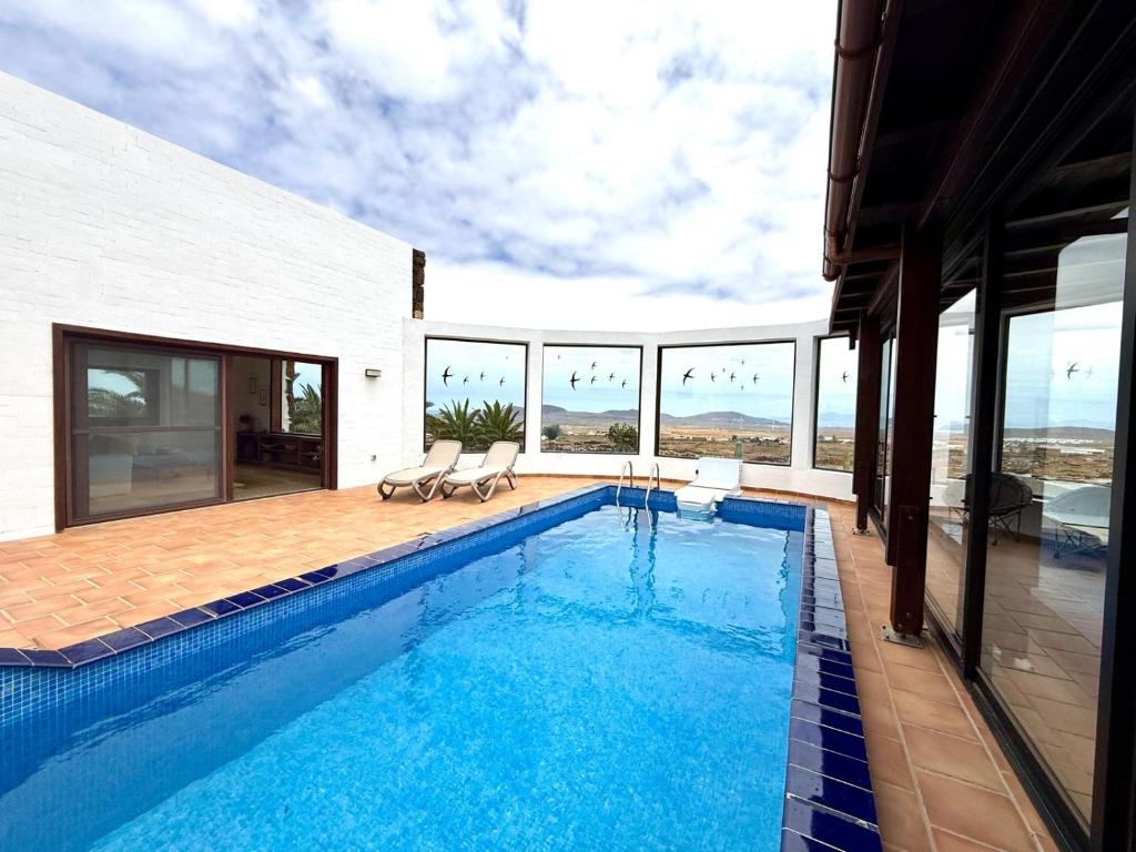 a swimming pool with a view of a house at Casa Estela in Villaverde