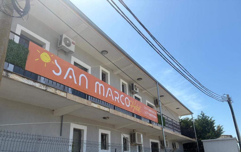 a building with a sign on the side of it at San Marco in Velipojë