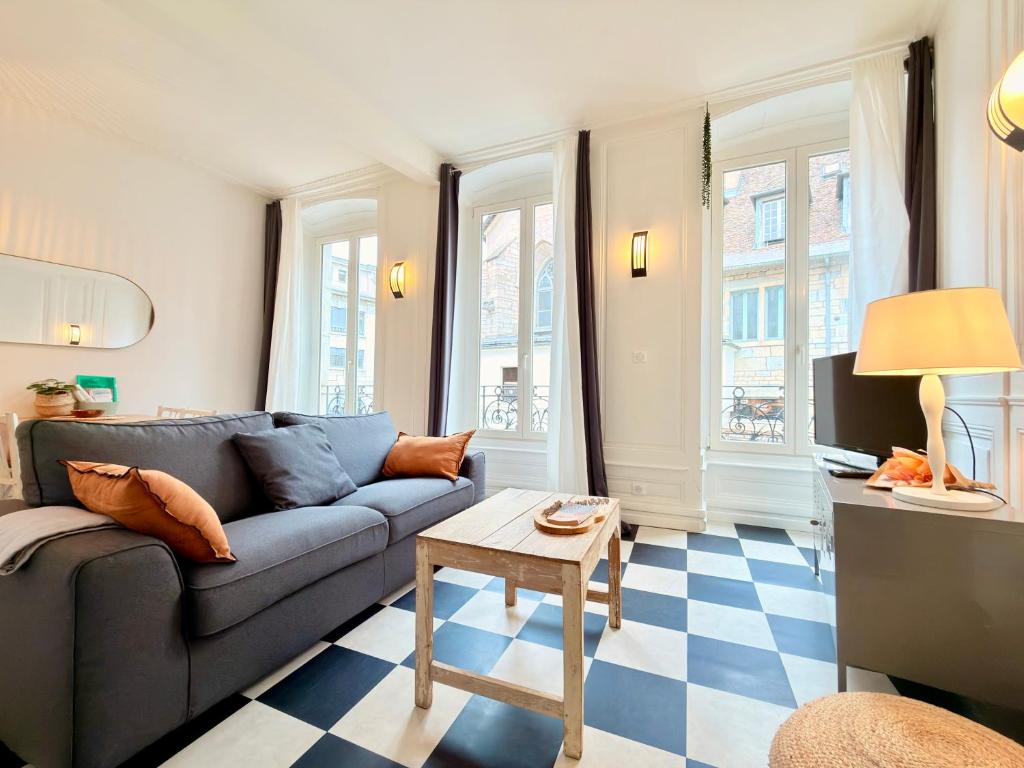 a living room with a couch and a table at Le Chamily in Besançon