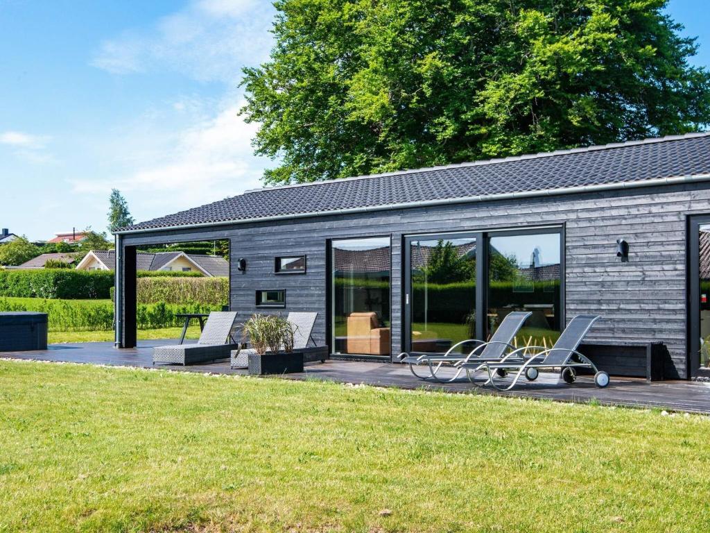 a house with two lounge chairs on a deck at 5 star holiday home in Hejls in Hejls