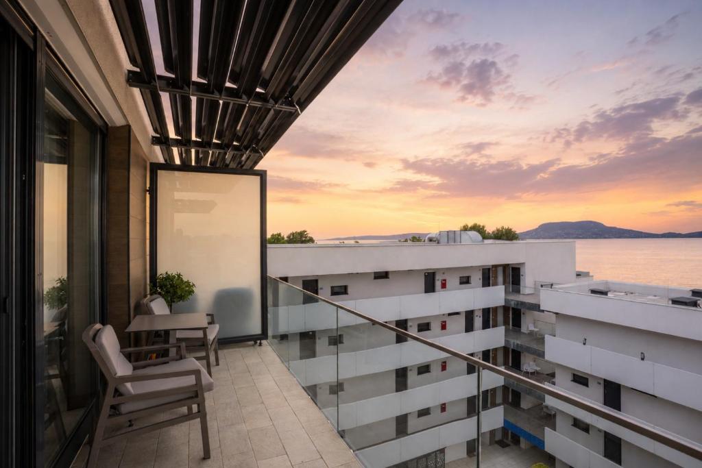 a balcony of a building with a view of the water at Panorama apartman at Sunset Resort in Fonyód