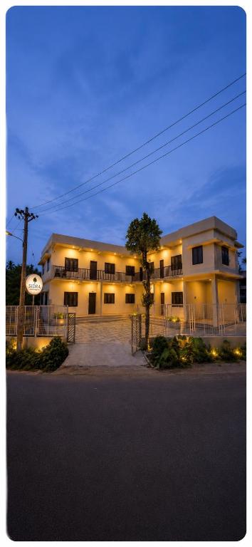 a large white building with a tree in front of it at Sidra Apartments - Spacious 2BHK Family Stay in Nilgiris, Pandalur, Tamil Nadu in Pandalūr